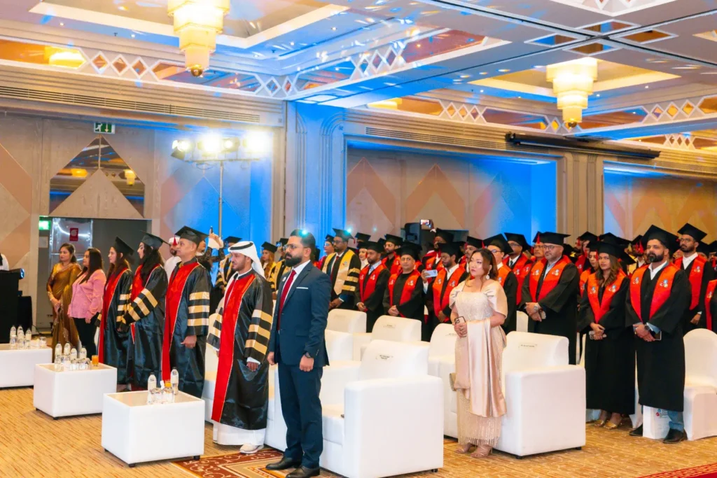 Graduates standing in a ballroom during a Global Career Pathway graduation ceremony